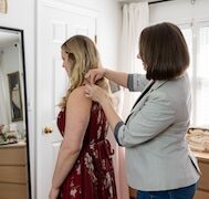 A seamstress pinning a casual dress on a client