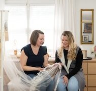 A seamstress consulting with a client talking about a wedding veil